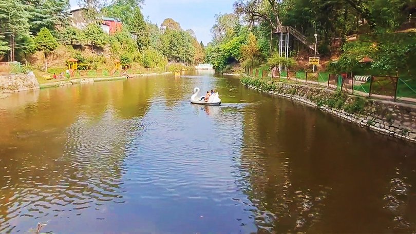 “Calm artificial lake Rani Jheel reflecting pine trees – best things to do in Ranikhet for boating and quiet moments”