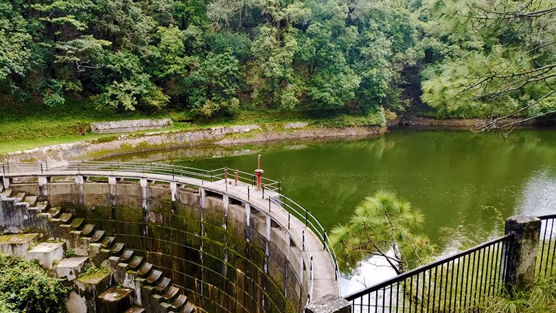 “Peaceful artificial lake surrounded by pine forests at Bhalu Dam, Ranikhet – best things to do in Ranikhet for picnics and nature lovers”