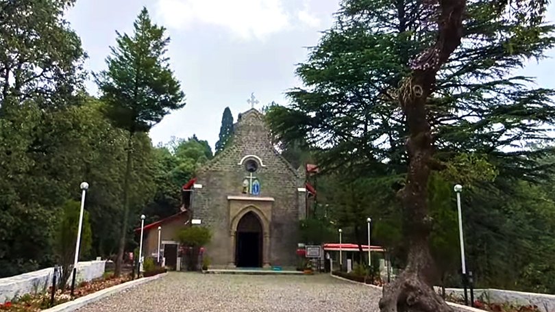 Historic St. John’s Church with stone walls and tall pine trees, showcasing colonial charm in Lansdowne