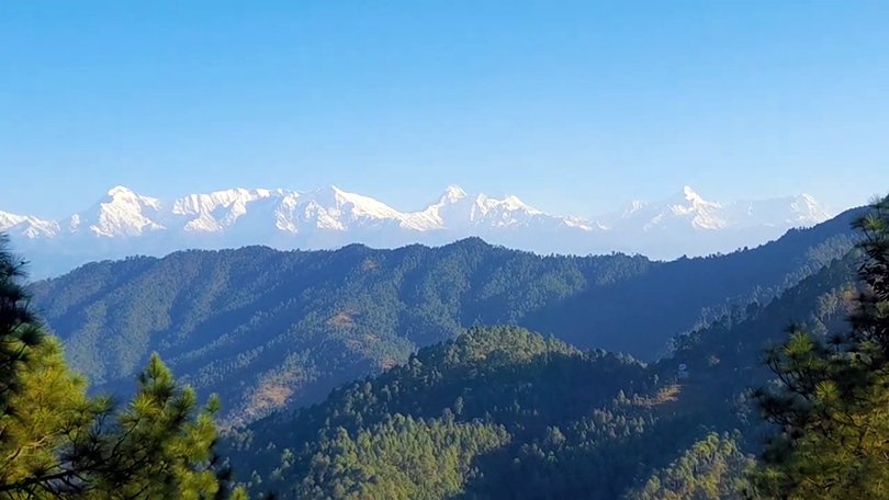Stunning Himalayan mountain views from Binsar Uttarakhand with lush forests, sunrise colors, and peaceful hill scenery.