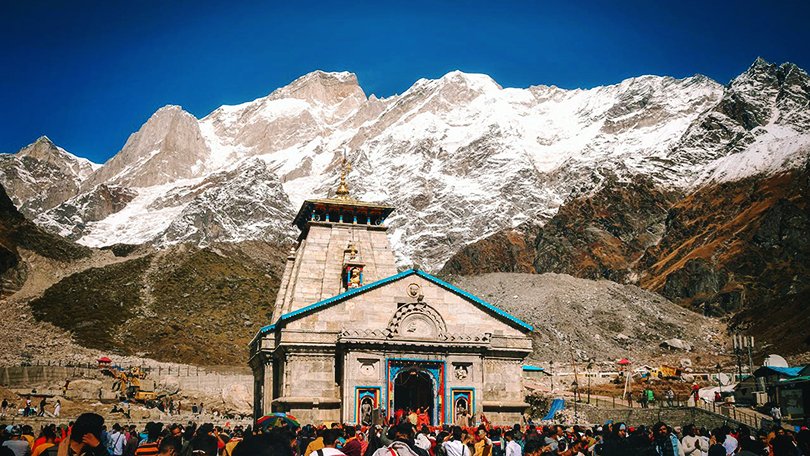 Kedarnath Temple 2026 with snow-clad Himalayan peaks, pilgrims visiting during yatra season – complete Kedarnath Dham Yatra Guide 2026
