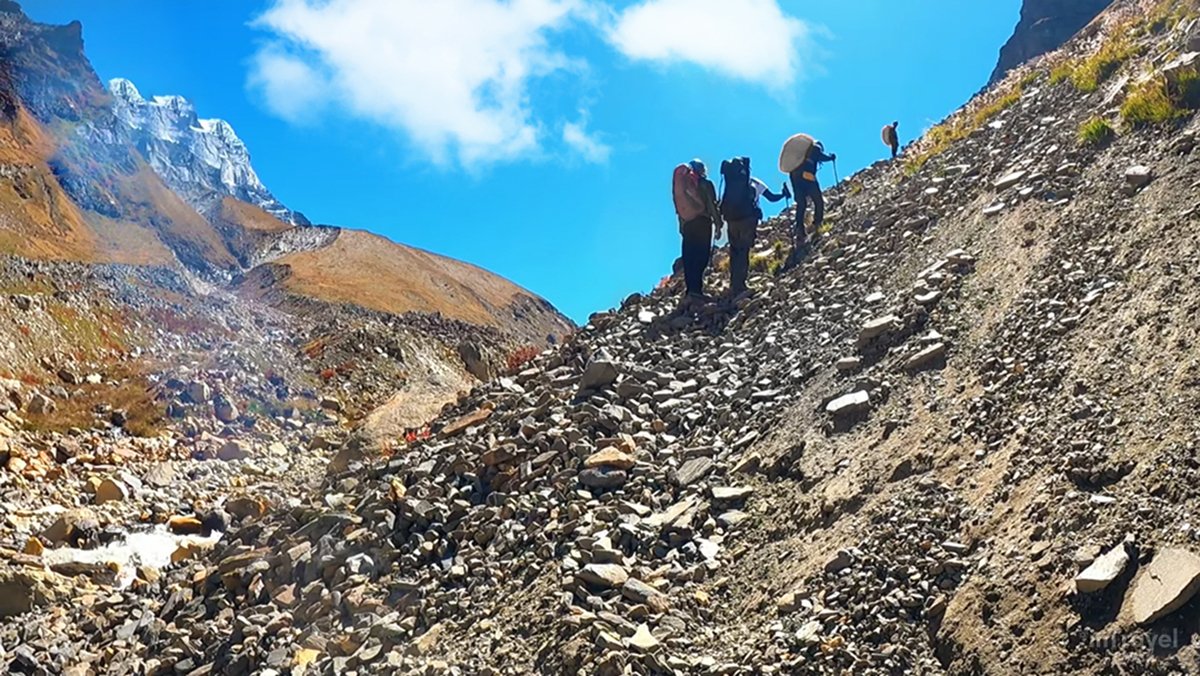 Group of trekkers climbing a steep Himalayan mountain during Kedar Tal Trek Guide 2026, symbolizing adventure and the spirit of exploration.