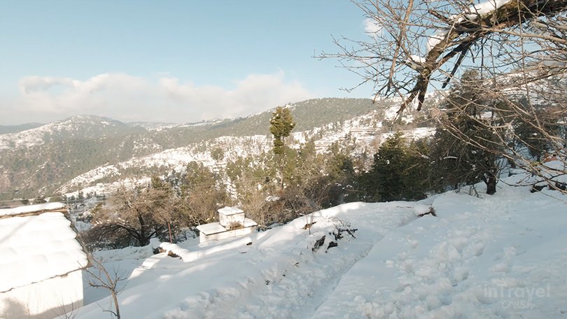 Mukteshwar winter scenery with snow-covered cliffs, forests and valley.