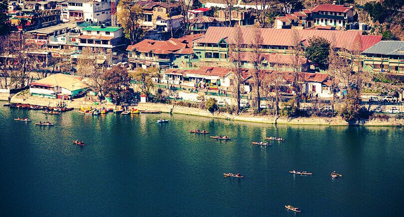 Crowded Mall Road along Naini Lake with shops and tourists in Nainital